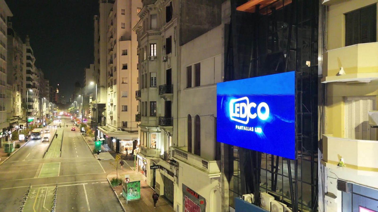 Vista nocturna de la avenida 18 de Julio con la pantalla LED del IMPO mostrando el logo de LEDCO