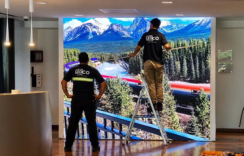 Técnicos de LEDCO trabajando frente a la pantalla LED de Trafigura