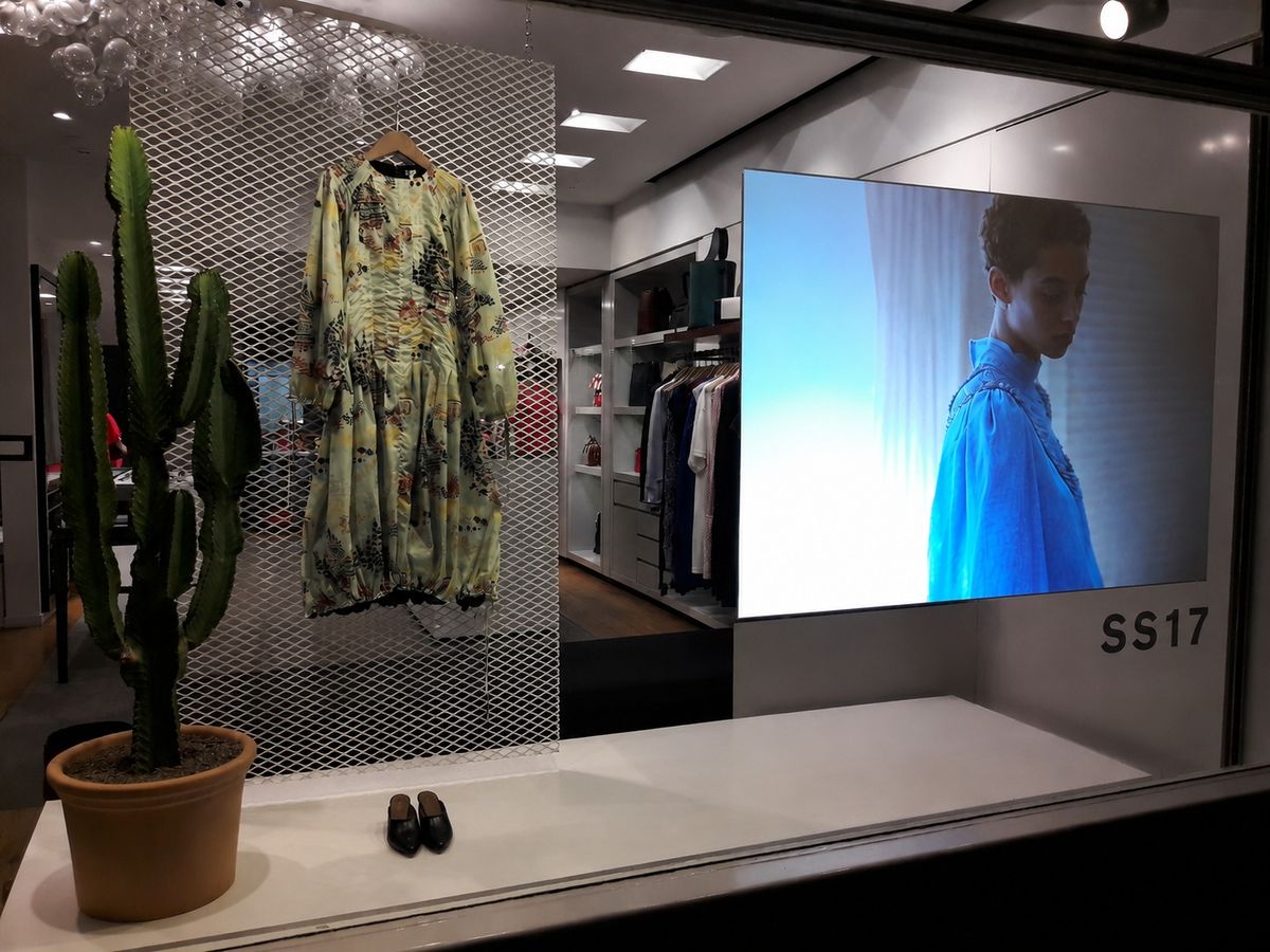 Pantalla LED instalada en la vidriera de un local, con el interior visible